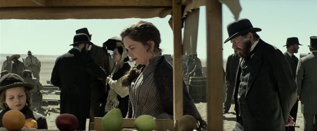Wide shot frame from The Lone Ranger — standing, table, hat