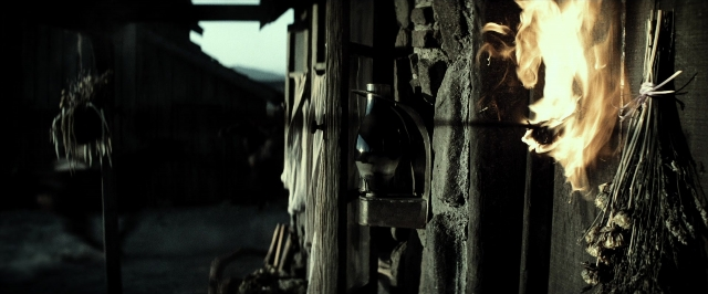 Wide shot frame from The Lone Ranger — fire, door handle