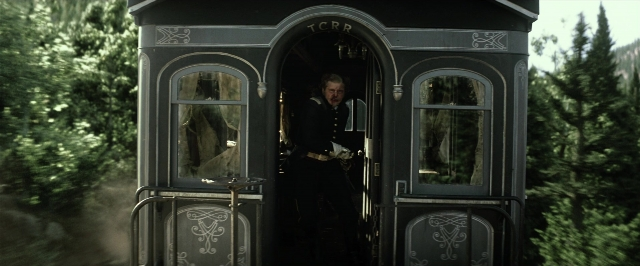 Wide shot frame from The Lone Ranger — standing, table, door