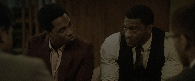 Wide shot frame from One Night in Miami — sitting, room, table