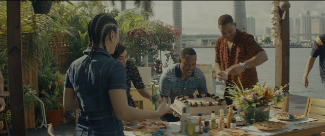 Wide shot frame from Bad Boys for Life — table, bottle, hair