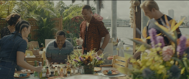 Wide shot frame from Bad Boys for Life — sitting, standing, table