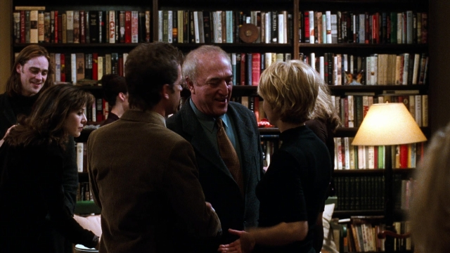 Wide shot frame from You've Got Mail — book, dialogue, suit