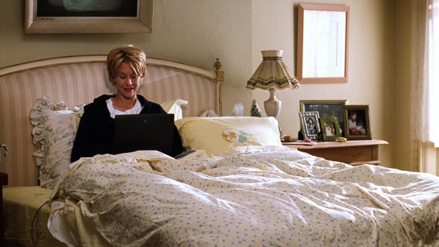 Wide shot frame from You've Got Mail — sitting, bed, lamp
