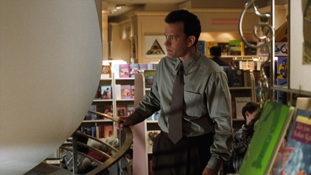 Wide shot frame from You've Got Mail — book, standing, tie