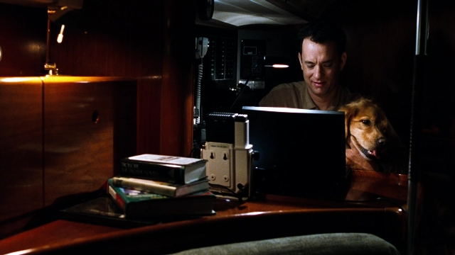 Wide shot frame from You've Got Mail — sitting, book, table