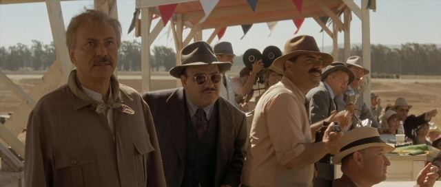 Wide shot frame from The Rocketeer — standing, dialogue, hat