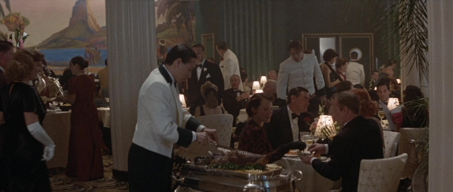Wide shot frame from The Rocketeer — sitting, standing, room