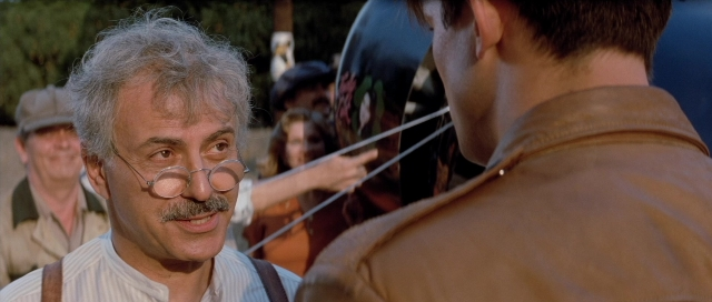 Medium shot frame from The Rocketeer — standing, dialogue, shirt