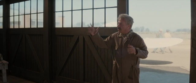 Wide shot frame from The Rocketeer — standing, walking, coat