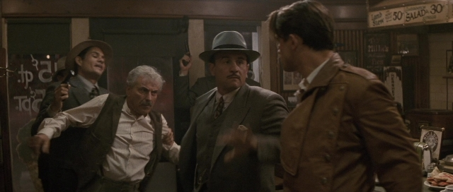 Wide shot frame from The Rocketeer — standing, room, table