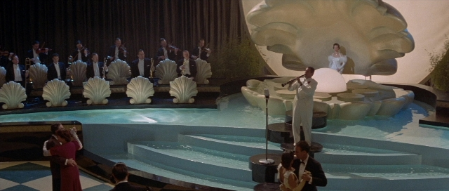 Wide shot frame from The Rocketeer — standing, suit, dress