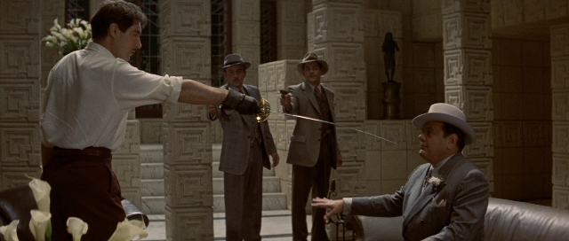 Wide shot frame from The Rocketeer — sitting, room, hand