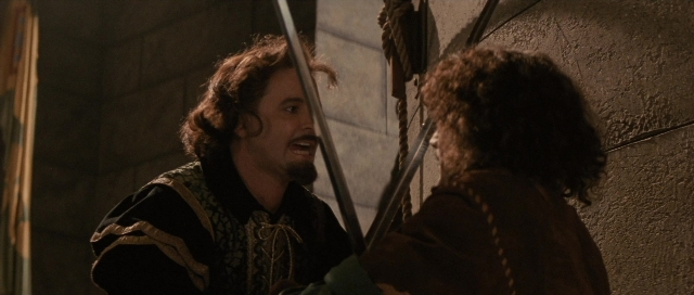 Wide shot frame from The Rocketeer — dialogue, beard, face