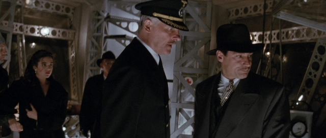 Wide shot frame from The Rocketeer — walking, room, hat