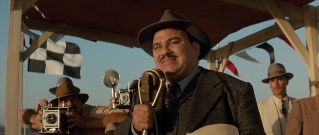 Wide shot frame from The Rocketeer — standing, hat, suit