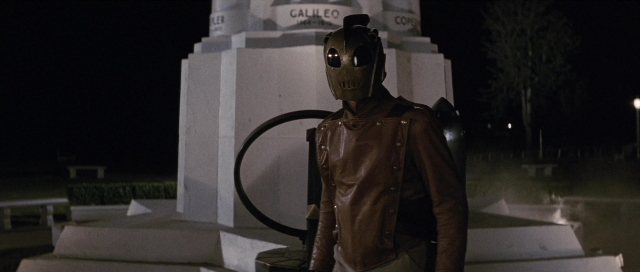 Medium shot frame from The Rocketeer — standing, hand, night