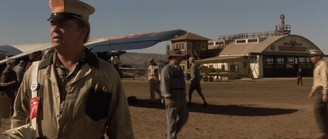 Wide shot frame from The Rocketeer — standing, walking, hat