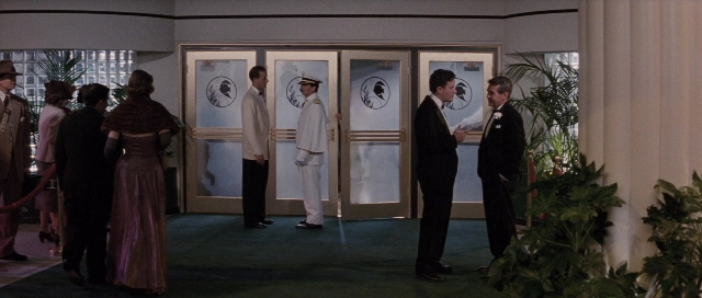 Wide shot frame from The Rocketeer — standing, room, door