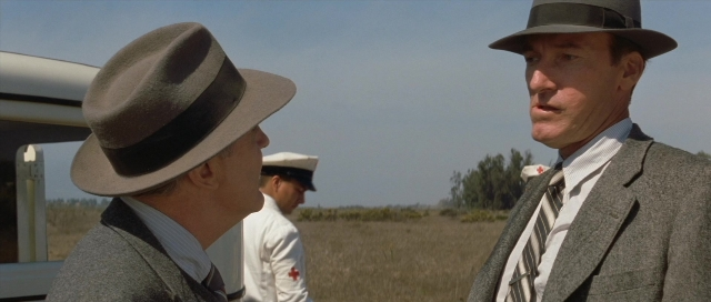 Wide shot frame from The Rocketeer — standing, hat, suit