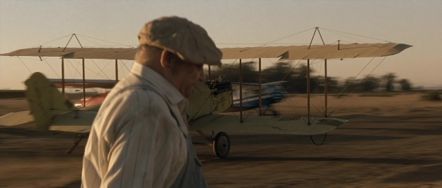 Wide shot frame from The Rocketeer — standing, hat, shirt