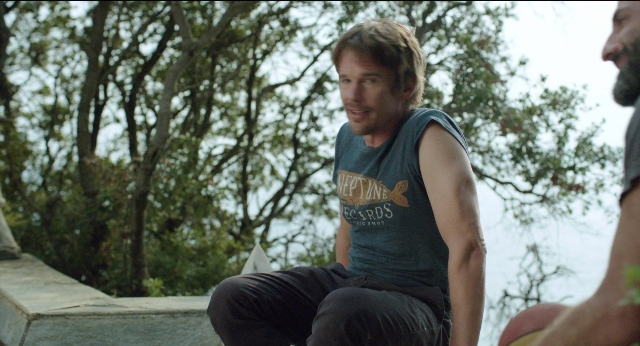 Medium shot frame from Before Midnight — sitting, beard, face