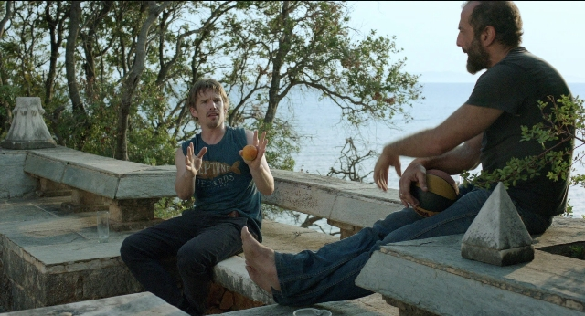 Wide shot frame from Before Midnight — sitting, walking, dialogue