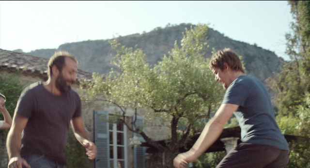 Wide shot frame from Before Midnight — hand, shirt, beard