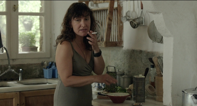 Wide shot frame from Before Midnight — standing, kitchen, hand