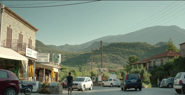 Wide shot frame from Before Midnight — walking, street, car