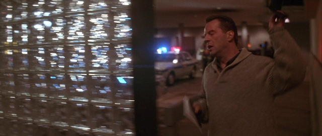 Wide shot frame from Die Hard 2 — standing, dialogue, car
