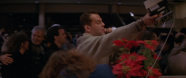 Wide shot frame from Die Hard 2 — flower, person, human face