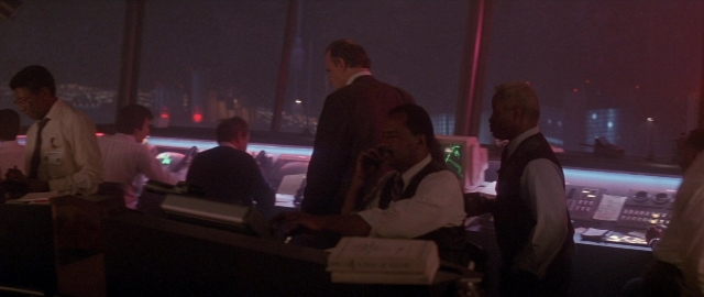Wide shot frame from Die Hard 2 — sitting, standing, room