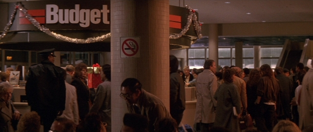 Wide shot frame from Die Hard 2 — dialogue, cigarette, person