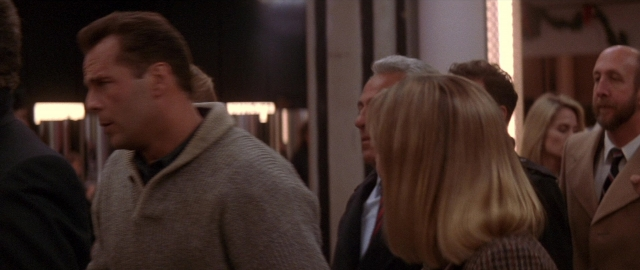 Wide shot frame from Die Hard 2 — room, dialogue, suit