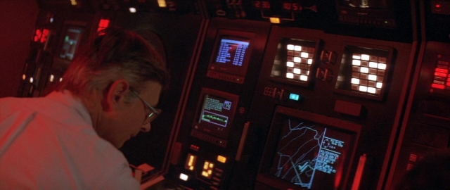Wide shot frame from Die Hard 2 — standing, room, hand