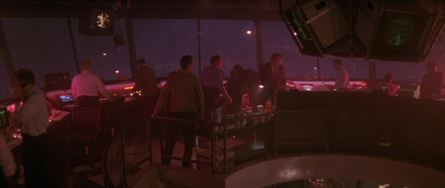 Wide shot frame from Die Hard 2 — standing, room, dialogue