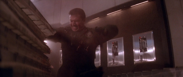 Wide shot frame from Die Hard 2 — standing, room, door