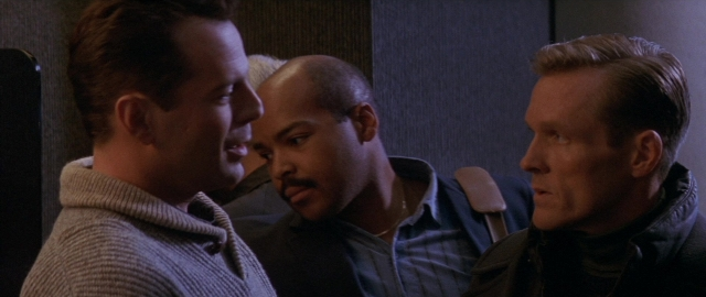Wide shot frame from Die Hard 2 — sitting, room, dialogue