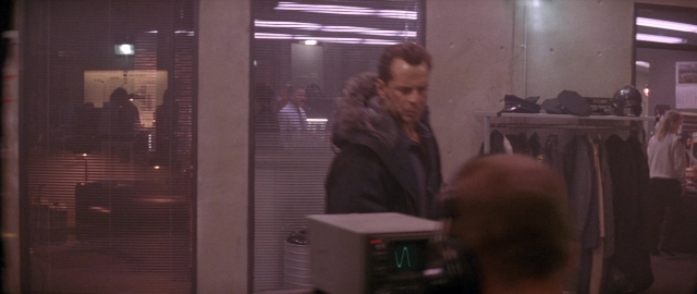 Wide shot frame from Die Hard 2 — standing, room, face