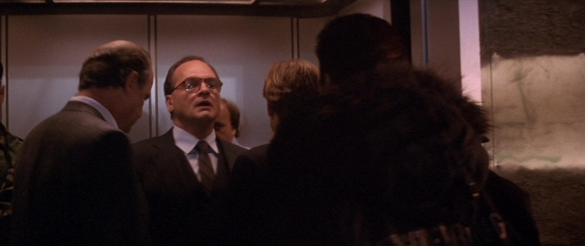 Wide shot frame from Die Hard 2 — standing, dialogue, suit