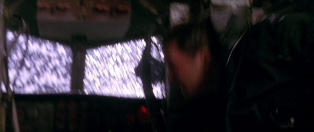 Wide shot frame from Die Hard 2 — room, car, face