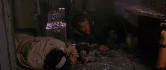 Medium shot frame from Die Hard 2 — room, table, fire