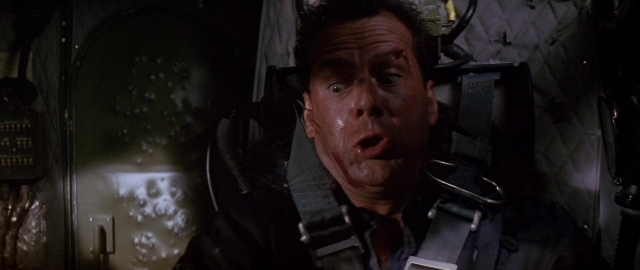 Medium shot frame from Die Hard 2 — room, suit, face