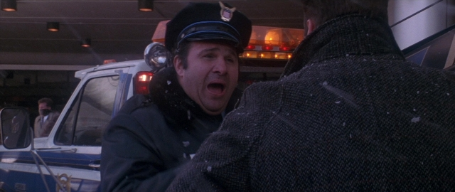 Wide shot frame from Die Hard 2 — standing, hat, uniform