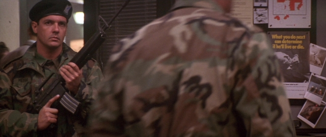 Wide shot frame from Die Hard 2 — room, hand, gun