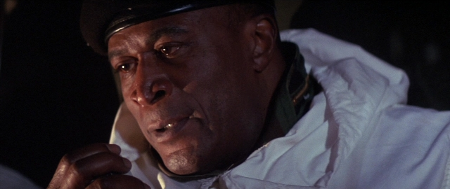 Wide shot frame from Die Hard 2 — hat, hand, face