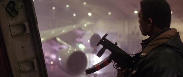 Frame from Die Hard 2 — standing, hand, gun