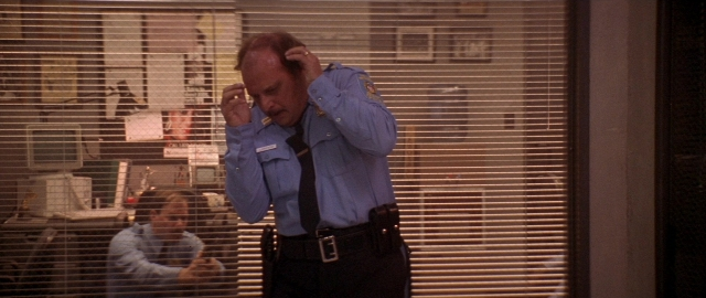 Frame from Die Hard 2 — sitting, standing, uniform