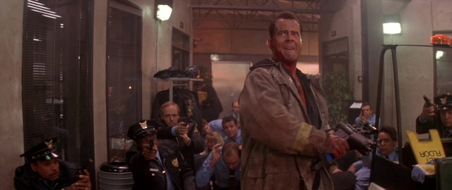 Wide shot frame from Die Hard 2 — standing, street, hand